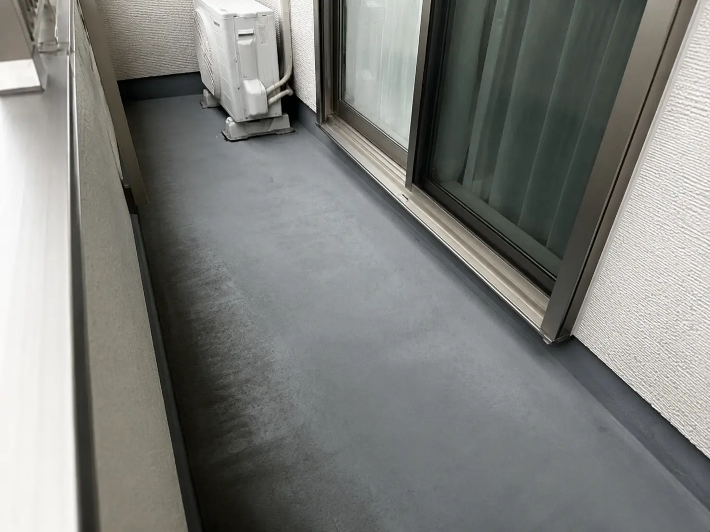 軽微な色むらと摩耗が見られるバルコニーのFRP防水床