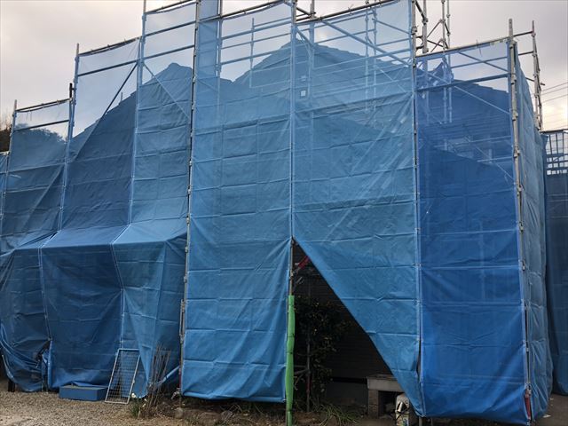 足場と飛散防止メッシュシートを設置した2階建て住宅