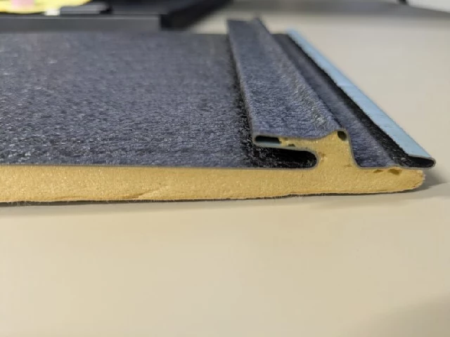 スーパーガルテクトの実物断面で金属屋根材の裏側に断熱材が一体化している様子