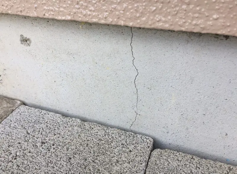 住宅基礎の表面に見られる細い縦方向のひび割れ